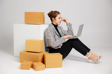 Portrait Asian smart entrepreneur business woman in casual suit surround by parcel boxes service...