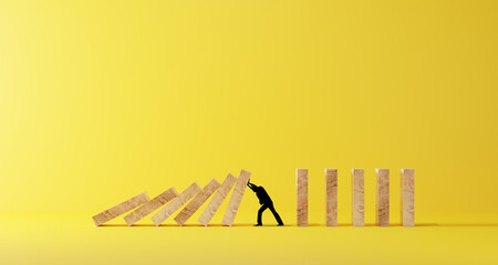 Silhouette of a man in panic against collapsing wooden dominos. Business crisis and failure concept...