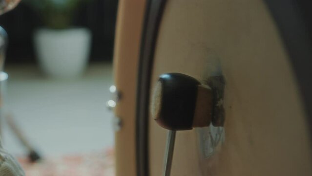 Close-up view of beater striking kick drum as unrecognizable musician playing drum kit