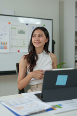 Young Asian woman working on laptop and drinking coffee in living room relaxing at home. Asian business woman working with financial documents Calculator, calculations, holiday concept at work.