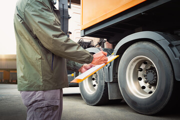 Truck Drivers Holding A Clipboard Checking Truck Wheels Tires. Semi Truck Tires. Maintenance...