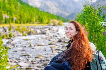 Naklejka premium Portrait of a beautiful redhead long haired woman on the background of mountains and multinsky lake
