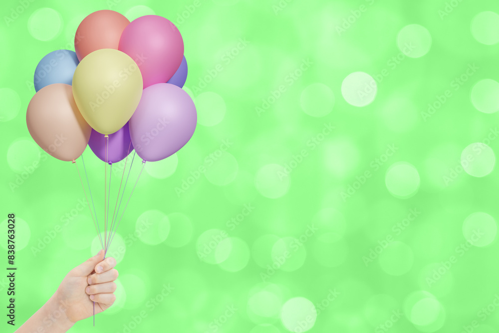 Aufkleber female hand holds bunch of colorful balloons on green summer blurred background. empty space for tex