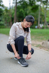 Young asian sporty women tying shoelaces running shoes to getting ready for run training and...