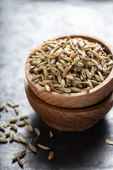 Indian spice fennel in wooden bowls close-up on gray background, vertical shot