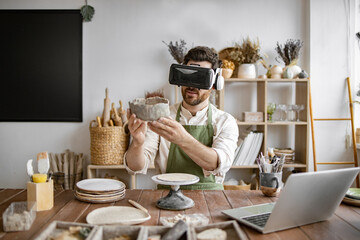 Man wearing virtual reality headset while making pottery art in creative workshop. Immersive...