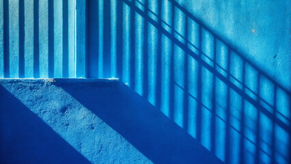 Minimalistic background with shadow on blue wall. Plaster texture