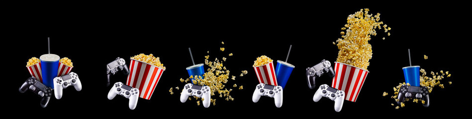 Paper bucket with popcorn, cup of drink and video game joystick on black