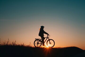 The silhouette of a person on a bicycle also captures the spirit of outdoor adventure.