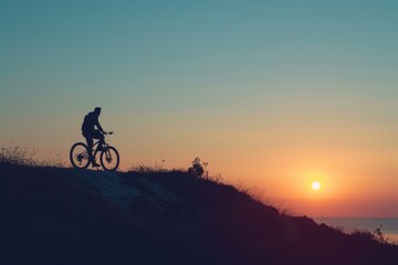 Obraz premium The silhouette of a person on a bicycle also captures the spirit of outdoor adventure.