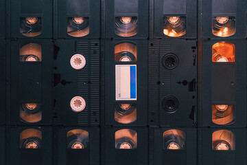 Set of old audio cassette tape on the wall background, large collection of analog black magnetic record technology