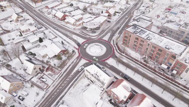 Traffic Flow Over Roundabout On Winterly Urban Landscape. Aerial Shot