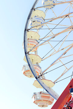 Close-up of a Ferris wheel against a clear blue sky at a carniva