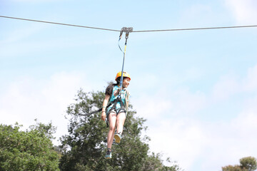 Teen's peaceful zip line fun in summer sun in Ojai, California.