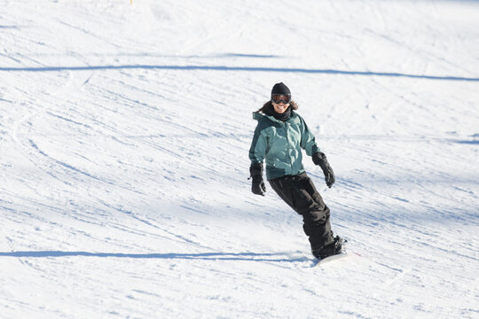 Woman snowboarding happily at June Mountain.