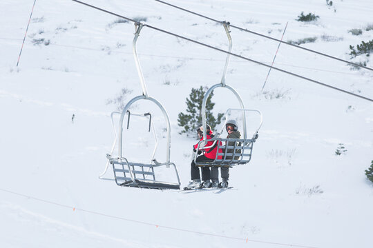 Boys riding the gondola up the mountain to ski.