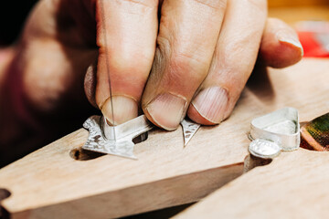 Close up of jewelers hand working with jewelers saw