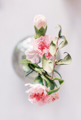 Overhead view of pink carnations in a delicate glass vase