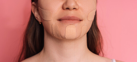 Face tape pasted all over lady's face on pink background.