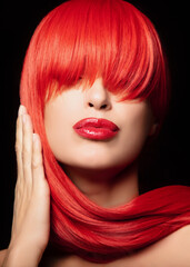 Beautiful woman with vibrant red dyed hair isolated on black background