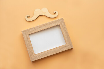 Father's Day concept with blank photo frame and decorative moustache on orange background.