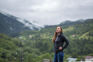 Naklejka premium Young woman enjoying fresh air and beautiful view in mountains