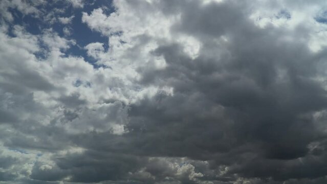 Cumulonimbus clouds evolving as they sweep across the sky with stormy grey undersides. Time lapse 60x.