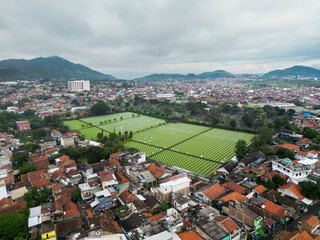 Stunning Aerial View of a Vibrant Cityscape with a Beautifully Manicured Cemetery Nestled Among...