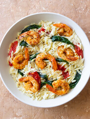Orzo pasta with shrimp, spinach and tomatoes. Italian Cuisine. Seafood.