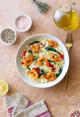 Orzo pasta with shrimp, spinach and tomatoes. Italian Cuisine. Seafood.