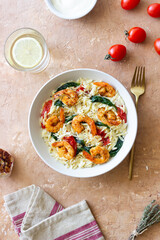 Orzo pasta with shrimp, spinach and tomatoes. Italian Cuisine. Seafood.