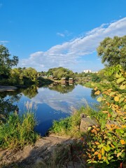 view of the river with its blue water and reflections of trees and clouds