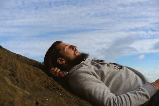 Man lying in the columns of the Reynisfjara on Reynisdrangar beach.