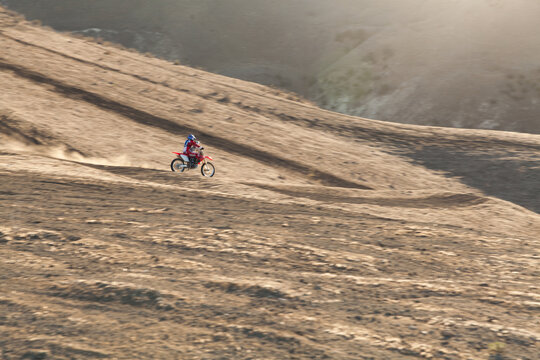 Skilled father and son riding on a dirt bike together.