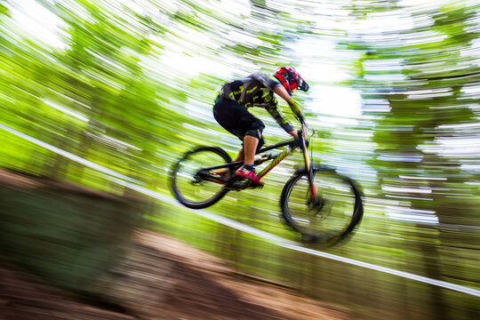 Downhill Mountain Biker Speeding off Jump