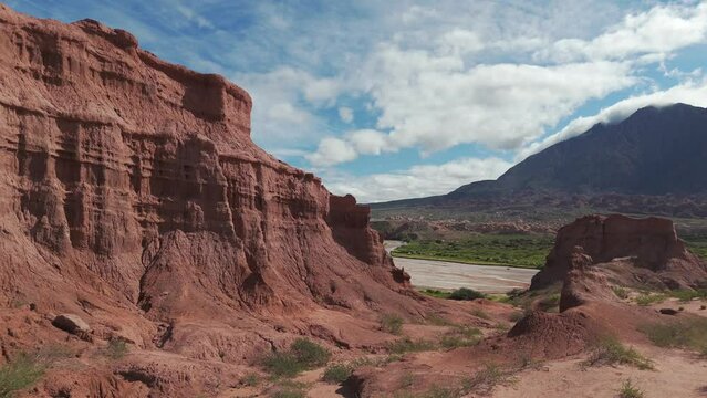 Red rock formations and lush greenery in Route 68, Quebrada de las Conchas, Salta under a bright blue sky