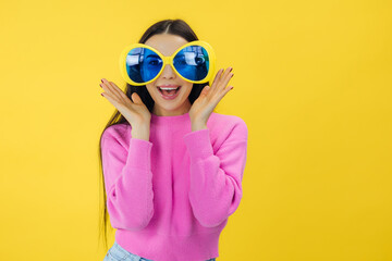 cute lovely girl wear stylish clothes and party sunglasses look camera isolated on yellow color background