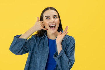 Funny young woman girl doing phone gesture says call me back pointing index finger aside