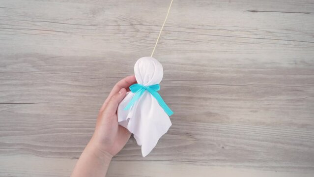 holding a little handmade doll called a teru teru bozu to wish for good weather tomorrow. てるてる坊主を持つ	
