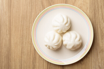 Steamed bun stuffed with barbecued pork, Asian cultural food on brown table background