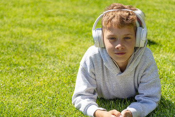 A boy relaxing on grass, listening to music
