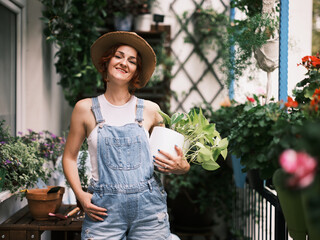 Smiling woman in casual attire exhibits her green thumb with a home gardening project