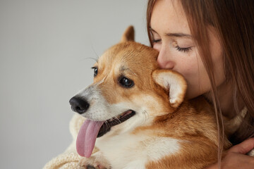 girl hugging Corgi dog, caring for animals and love for dogs