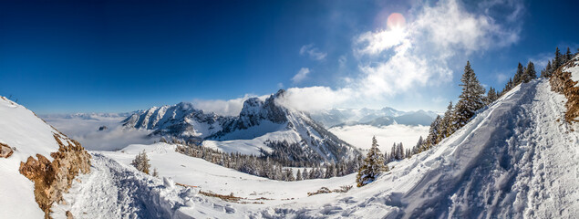 Majestic mountain landscape in winter with cloud formation on mountain peaks in the European Alps between Germany and Austria