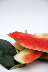Watermelon peel on a white background. Close-up watermelon peel texture with copy space. Concepts of summer fruit, cooking, and cutting for food and drink. Pieces of ripe watermelon peels.