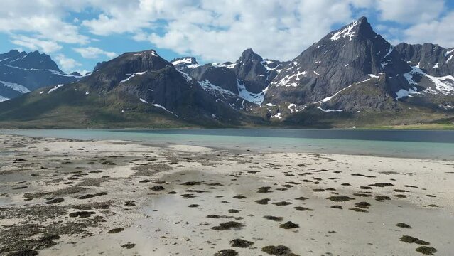 Aerial view in orbit over the beautiful Morpheus beach with large snowy mountains. On the Lofoten Islands, Norway.