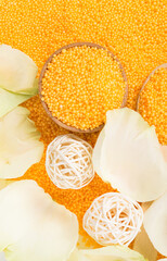 orange salt background for taking spa treatments with white rose petals, top view
