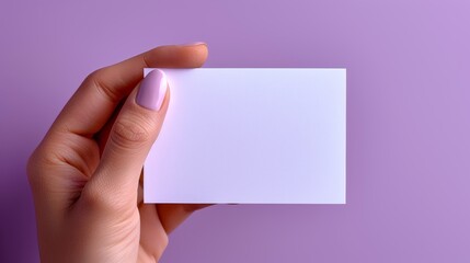 Obraz premium hand holding card on a purple background 