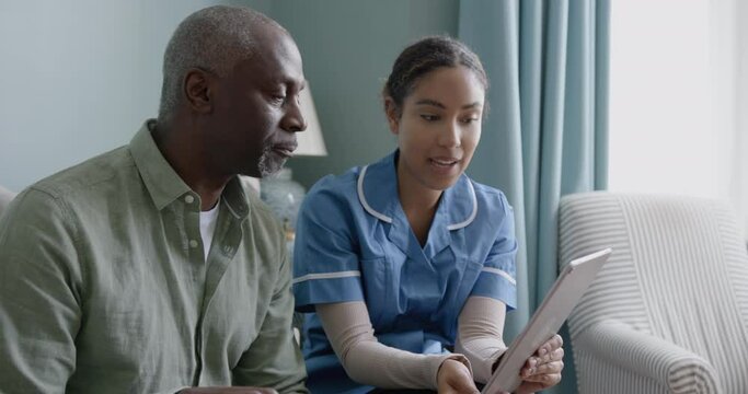 Nurse showing Patient Health results using a Digital tablet on a Home visit