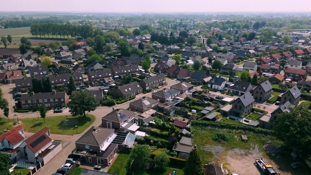 Aerial footage of Budel residential area, showcasing neat rows of houses, tree-lined streets, and well-maintained gardens. Captured on a clear day, highlighting the serene suburban atmosphere.
